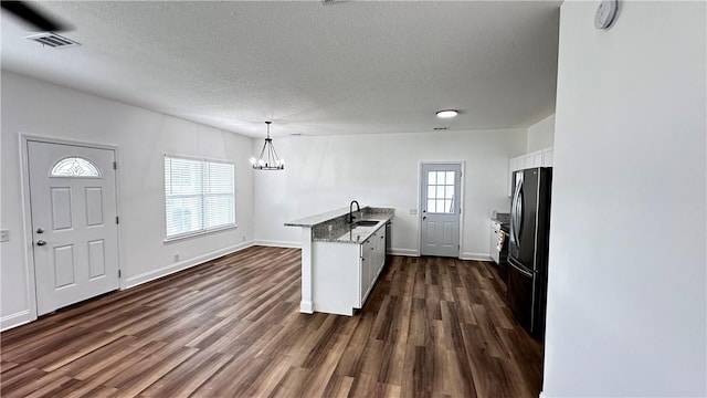 kitchen with dark hardwood / wood-style flooring, decorative light fixtures, white cabinetry, and sink