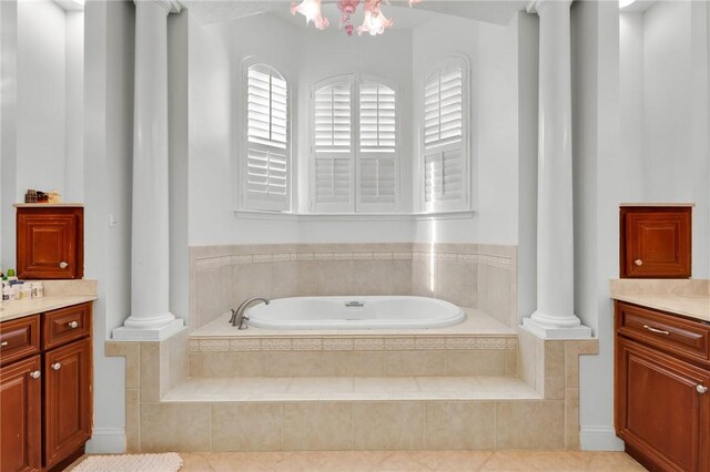 bathroom with a garden tub, vanity, and decorative columns