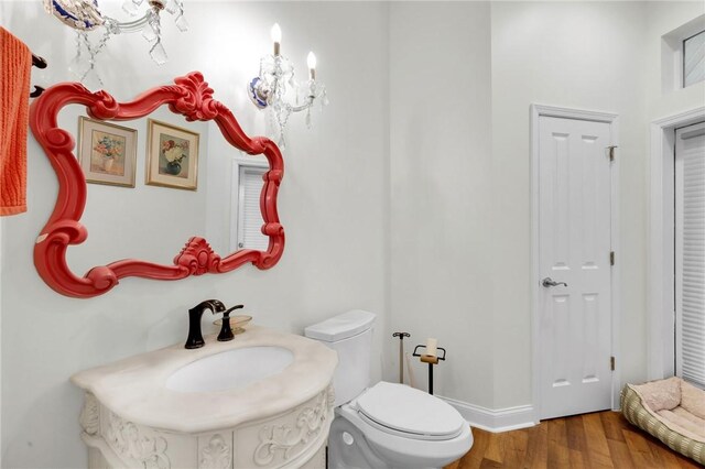 bathroom with baseboards, toilet, and wood finished floors