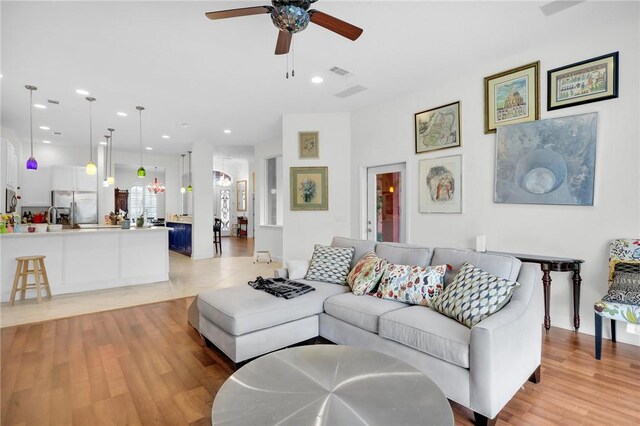 living area featuring light wood-type flooring, ceiling fan, visible vents, and recessed lighting