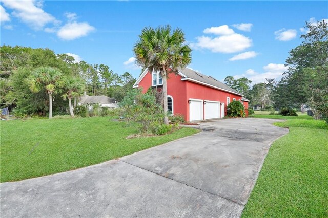 view of side of property featuring a garage, a yard, concrete driveway, and stucco siding