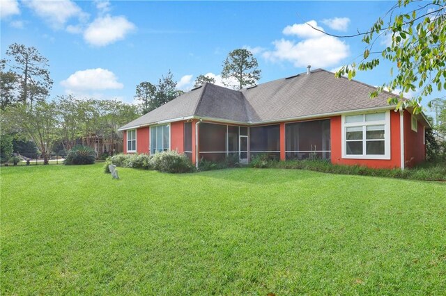 back of house featuring a yard and a sunroom