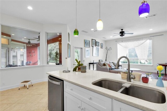 kitchen featuring visible vents, white cabinets, a sink, light stone countertops, and dishwasher