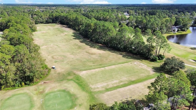 birds eye view of property featuring view of golf course, a water view, and a wooded view