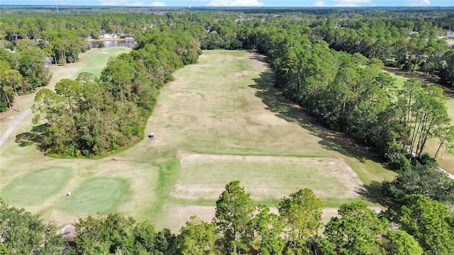 aerial view with golf course view and a view of trees