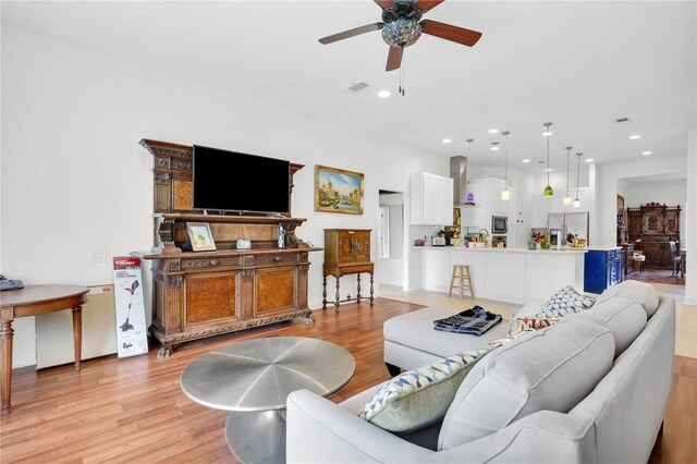 living area featuring visible vents, ceiling fan, light wood-style flooring, and recessed lighting