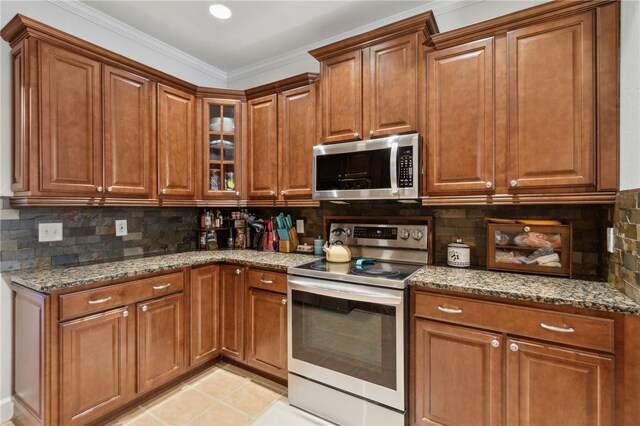 40 Jada Ln, Brunswick, GA 31523 - kitchen featuring appliances with stainless steel finishes, stone countertops, brown cabinets, and ornamental molding