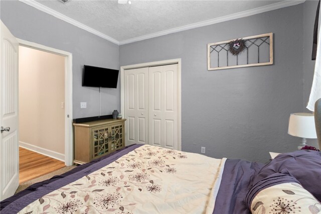 40 Jada Ln, Brunswick, GA 31523 - bedroom with crown molding, a closet, wood finished floors, a textured ceiling, and baseboards