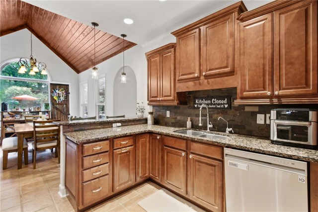 40 Jada Ln, Brunswick, GA 31523 - kitchen featuring dishwasher, a sink, stone countertops, a peninsula, and brown cabinets