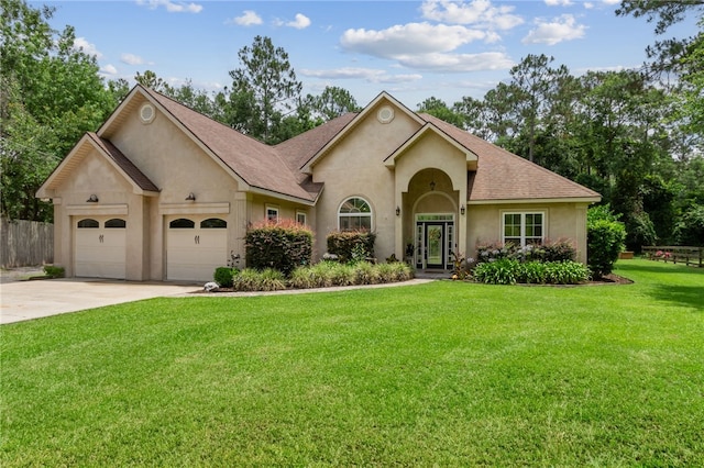 40 Jada Ln, Brunswick, GA 31523 - view of front of house with stucco siding, driveway, a garage, and roof with shingles