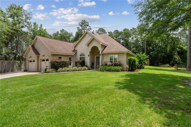 40 Jada Ln, Brunswick, GA 31523 - ranch-style home featuring stucco siding, an attached garage, and driveway