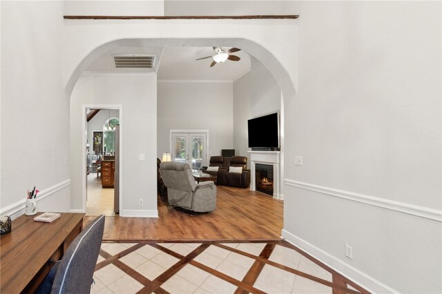 40 Jada Ln, Brunswick, GA 31523 - living room with arched walkways, inlaid floor details, crown molding, ceiling fan, and a high ceiling