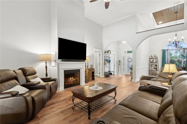 40 Jada Ln, Brunswick, GA 31523 - living room with high vaulted ceiling, ornamental molding, arched walkways, a chandelier, and light wood finished floors