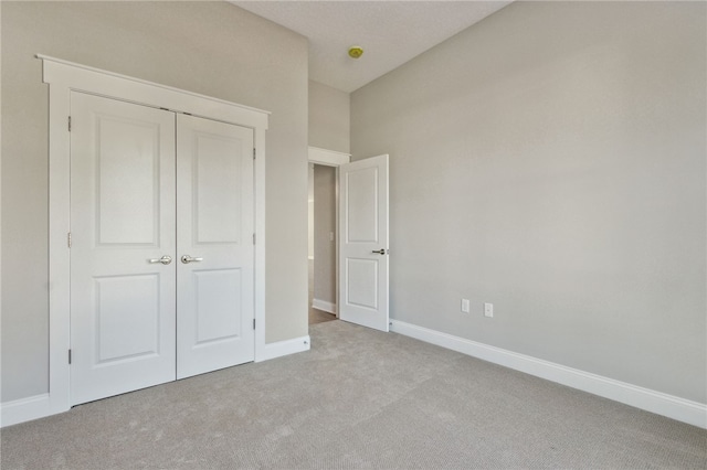 unfurnished bedroom featuring carpet, baseboards, and a closet