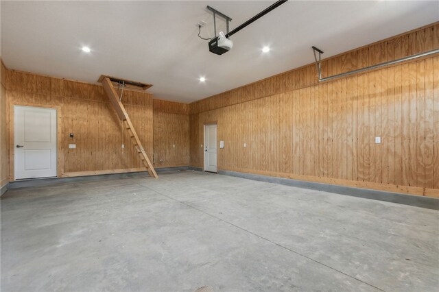 garage featuring wooden walls and a garage door opener