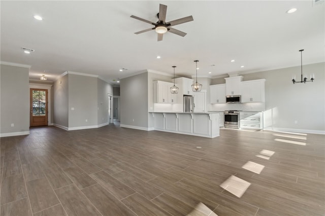 unfurnished living room with recessed lighting, baseboards, wood finished floors, and ceiling fan with notable chandelier