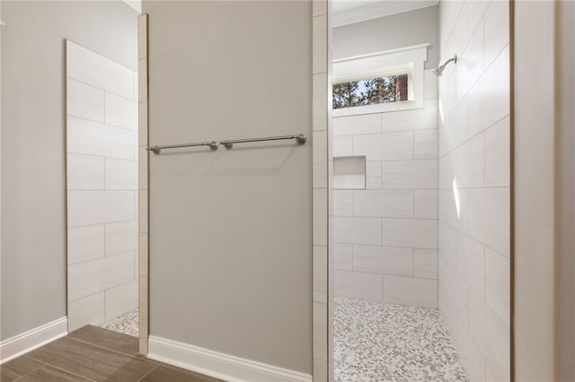 bathroom featuring a walk in shower and baseboards