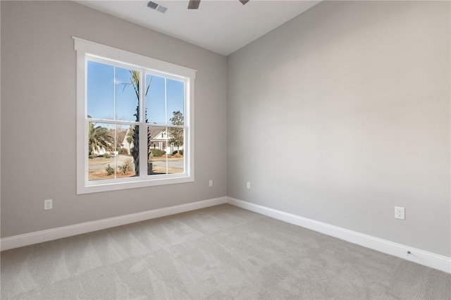 empty room with ceiling fan, baseboards, visible vents, and light carpet