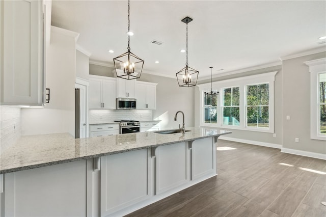 kitchen with a sink, stainless steel appliances, backsplash, and visible vents