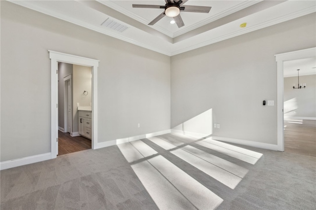 carpeted spare room featuring visible vents, baseboards, ceiling fan, ornamental molding, and a raised ceiling