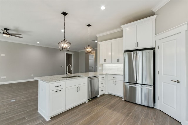 kitchen with a peninsula, wood finish floors, appliances with stainless steel finishes, and a sink