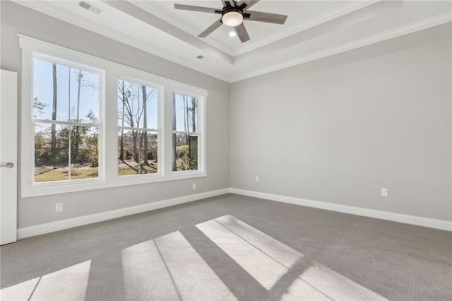 spare room featuring baseboards, visible vents, a tray ceiling, ceiling fan, and crown molding