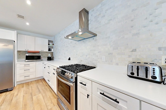 1625 Windsor Dr, Waycross, GA 31501 - kitchen featuring tasteful backsplash, light wood-type flooring, stainless steel appliances, wall chimney exhaust hood, and visible vents
