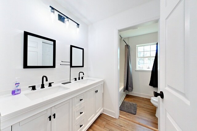 1625 Windsor Dr, Waycross, GA 31501 - bathroom featuring baseboards, wood finished floors, a sink, and toilet