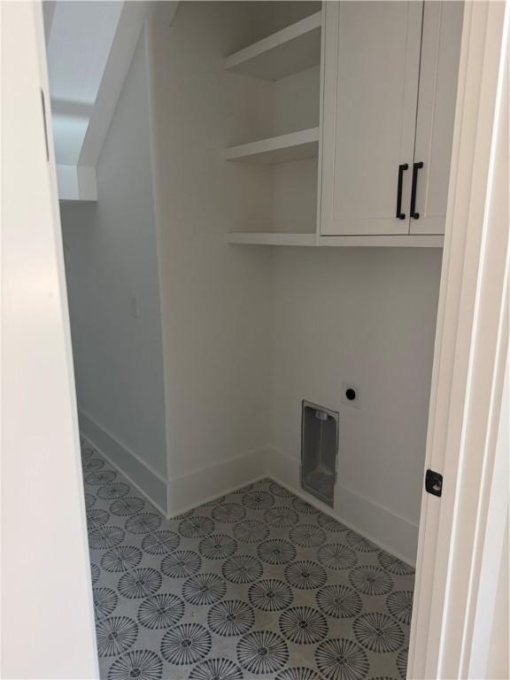 1912 First Ave, Saint Simons Island, GA 31522 - laundry area featuring electric dryer hookup, tile patterned flooring, and cabinet space