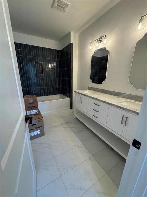 1912 First Ave, Saint Simons Island, GA 31522 - bathroom featuring vanity, marble look tiles, and shower / bath combination
