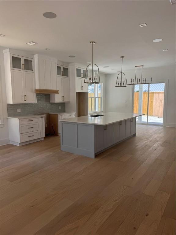 1912 First Ave, Saint Simons Island, GA 31522 - kitchen with white cabinets, healthy amount of natural light, light wood-type flooring, a chandelier, and recessed lighting