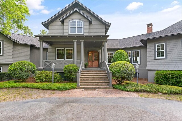 view of front of house featuring a chimney, a front yard, and curved driveway