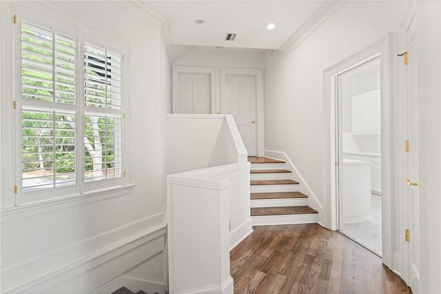 stairs with recessed lighting, wood finished floors, a wealth of natural light, and visible vents