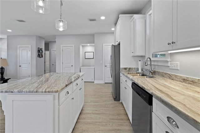 502 Ridge Rd, Darien, GA 31305 - kitchen featuring a sink, appliances with stainless steel finishes, light wood-style floors, a center island, and white cabinetry