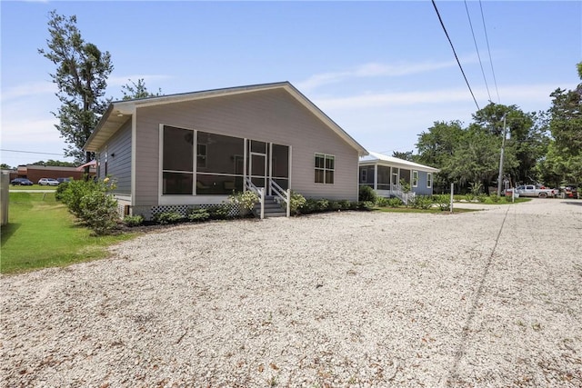 502 Ridge Rd, Darien, GA 31305 - back of property with a sunroom and gravel driveway