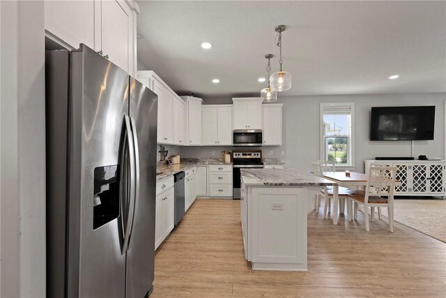 502 Ridge Rd, Darien, GA 31305 - kitchen with stainless steel appliances, a kitchen island, white cabinetry, recessed lighting, and light stone countertops
