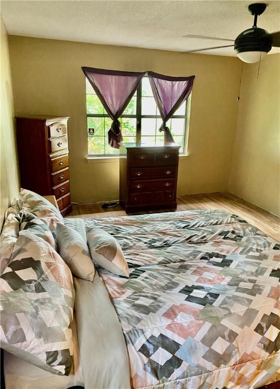 126 Lake View Cir, Brunswick, GA 31525 - bedroom with ceiling fan, wood finished floors, and a textured ceiling