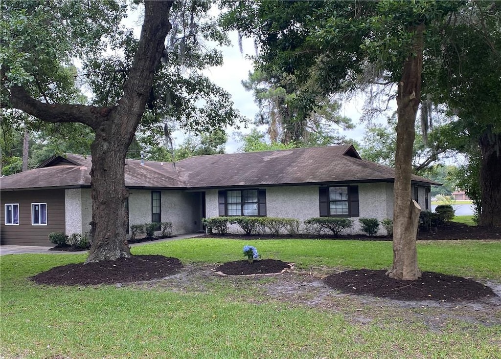 single story home with stucco siding and a front lawn