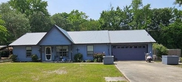 300 Crestview Dr, Woodbine, GA 31569 - single story home with an attached garage, a front yard, concrete driveway, and metal roof