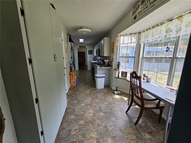 300 Crestview Dr, Woodbine, GA 31569 - kitchen featuring a textured ceiling, dark stone finish floors, and baseboards