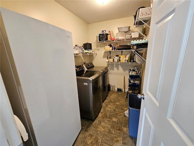 300 Crestview Dr, Woodbine, GA 31569 - laundry area featuring washing machine and dryer, a textured ceiling, and stone finish flooring