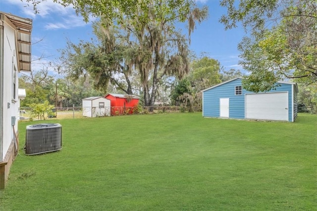 view of yard featuring an outbuilding, fence, a storage shed, and central AC unit