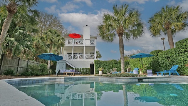 view of swimming pool featuring stairs, fence, and a fenced in pool