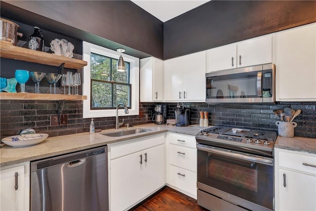 kitchen featuring stainless steel appliances, white cabinetry, and a sink