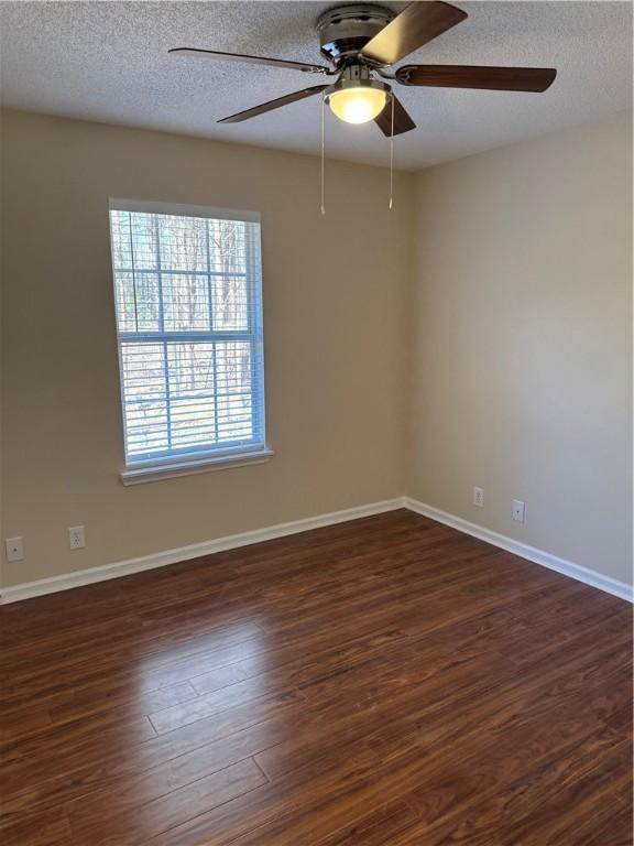 unfurnished room featuring dark hardwood / wood-style floors and a textured ceiling