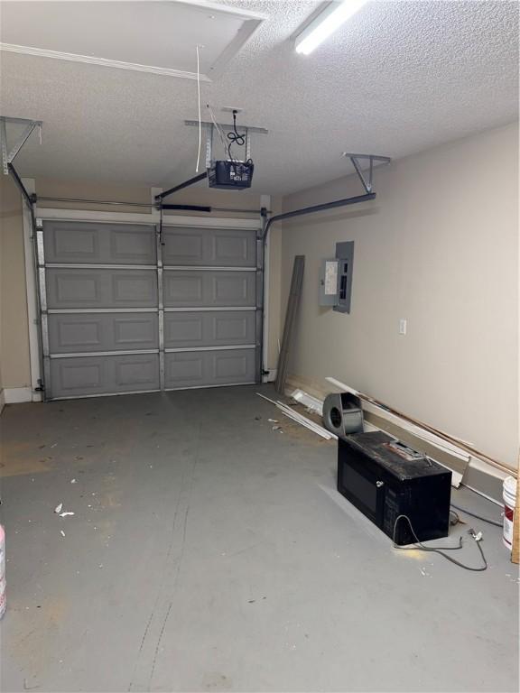 garage with a garage door opener and electric panel