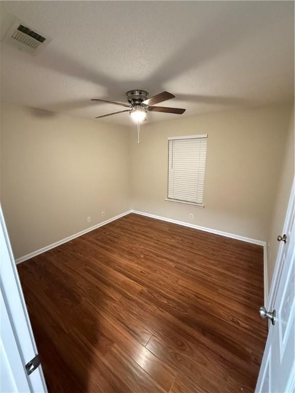 spare room featuring dark hardwood / wood-style flooring and ceiling fan