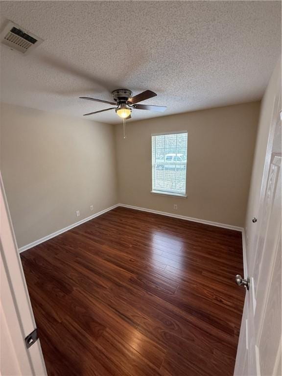 unfurnished room featuring ceiling fan, dark wood-type flooring, and a textured ceiling