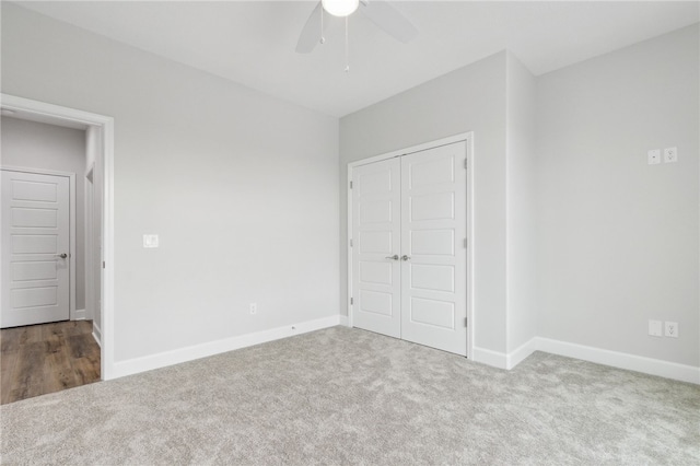 unfurnished bedroom featuring ceiling fan, light colored carpet, and a closet