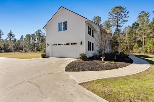 view of side of property featuring concrete driveway and an attached garage